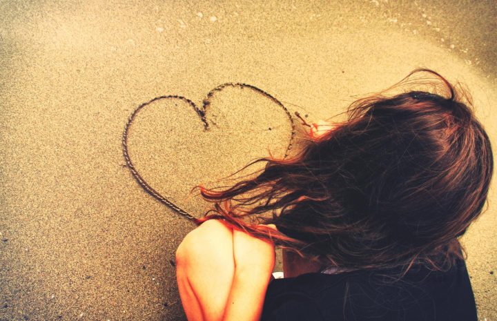 Une personne dessine un cœur dans le sable sur une plage, symbole d'amour, de tendresse et de souvenirs partagés. Cette image chaleureuse évoque les sentiments sincères, idéale pour accompagner un message d'amour, une pensée romantique, la Saint-Valentin ou une déclaration affectueuse.