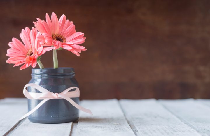Un joli bouquet de gerberas roses disposé dans un petit vase gris orné d'un ruban délicat apporte une touche de douceur et d'élégance. Posées sur une table en bois clair, ces fleurs aux couleurs tendres évoquent l'affection, la gentillesse et les petites attentions du quotidien. Une image idéale pour souhaiter une bonne fête, offrir des fleurs virtuelles ou accompagner un message chaleureux à une personne chère.