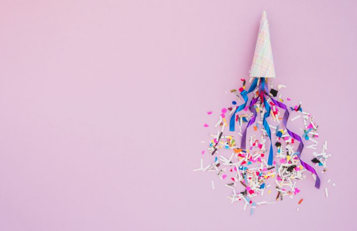 Un chapeau de fête entouré de confettis multicolores et de serpentins apporte une touche de gaieté sur un fond rose pastel. Cette composition joyeuse et colorée évoque les célébrations, les petites attentions et le plaisir de faire la fête. Une image idéale pour illustrer une fête, souhaiter une bonne fête à un proche ou accompagner un message chaleureux et plein de bonne humeur.